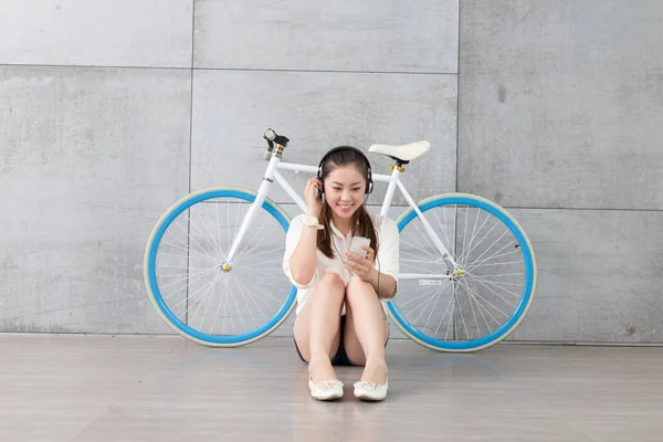 Chinese woman listening music with bike — Stock Photo, Image