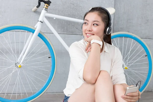 chinese woman listening music with bike