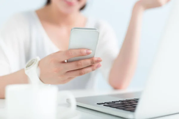 Жінка використовує ноутбук і мобільний телефон в офісі — стокове фото