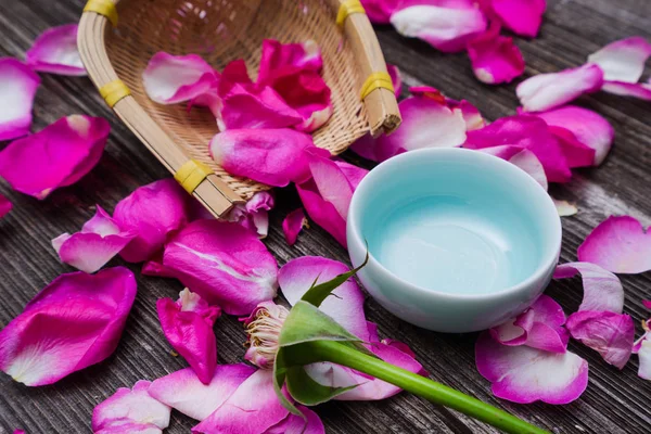 Blütenblätter roter Rosen auf dem Tisch — Stockfoto