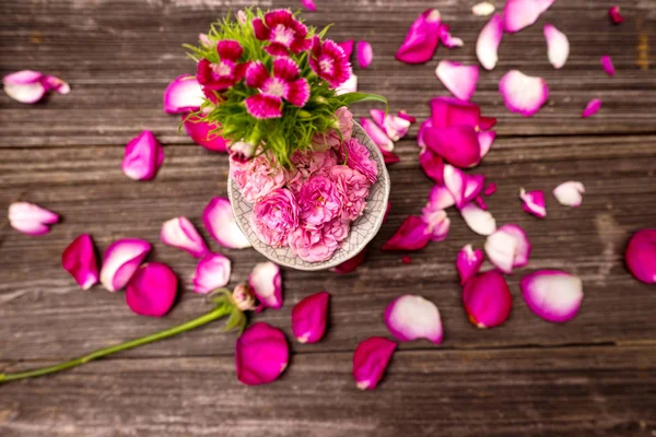 Bloemblaadjes van rode roos op tafel — Stockfoto