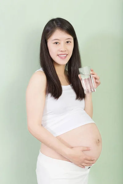 Jonge mooie zwangere vrouw met glas — Stockfoto