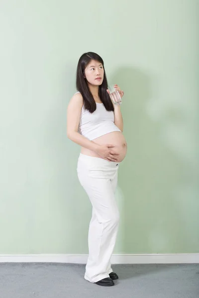 Young pretty pregnant woman with glass — Stock Photo, Image