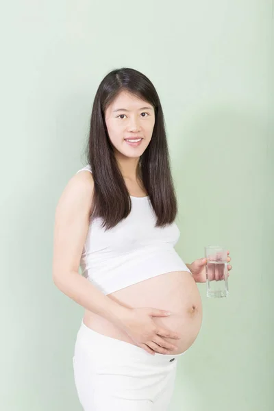 Young pretty pregnant woman with glass — Stock Photo, Image