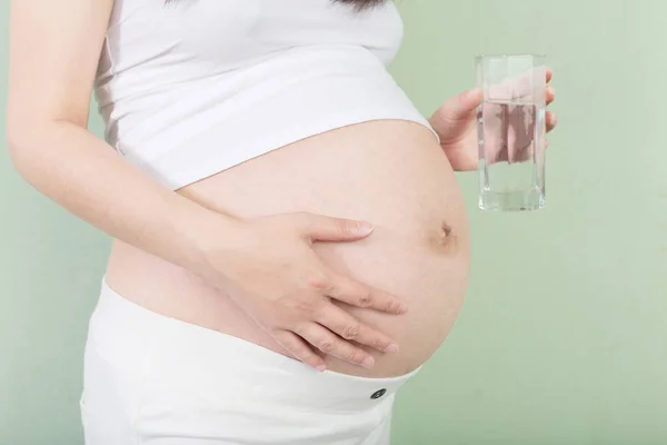 Mladá docela těhotná žena se sklem — Stock fotografie