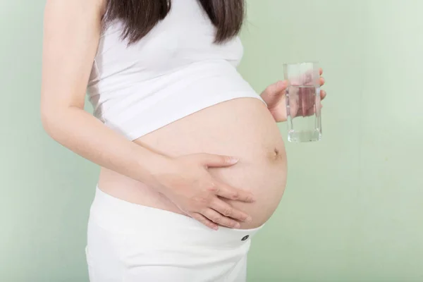 Young pretty pregnant woman with glass — Stock Photo, Image