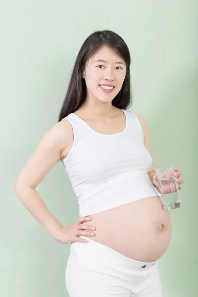 Jeune jolie femme enceinte avec verre — Photo