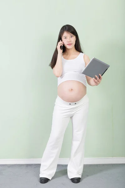 Mulher grávida com tablet e telefone celular — Fotografia de Stock