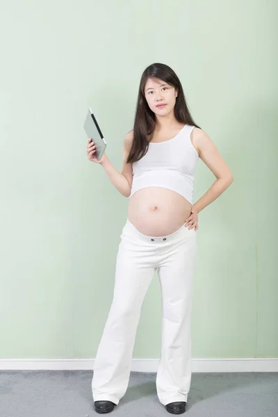 Young pretty pregnant woman with tablet — Stock Photo, Image