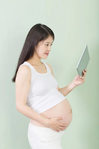 Jovem mulher grávida bonita com tablet — Fotografia de Stock