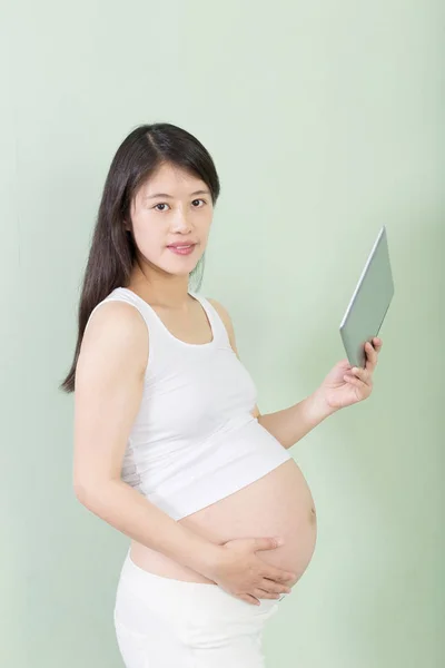 Joven bastante embarazada mujer con tableta —  Fotos de Stock