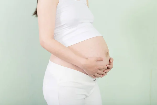 Mulher grávida segura a barriga — Fotografia de Stock
