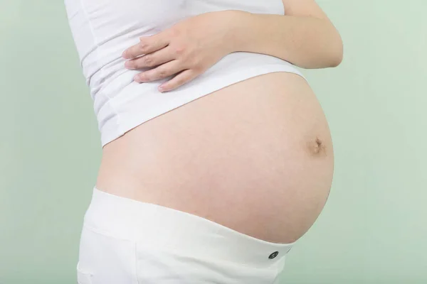 Mulher grávida segura a barriga — Fotografia de Stock