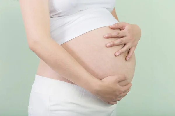 Pregnant woman holds her belly — Stock Photo, Image