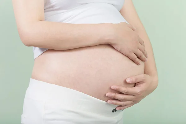 Pregnant woman holds her belly — Stock Photo, Image