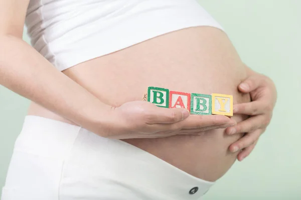 Young pretty pregnant woman with cubes — Stock Photo, Image