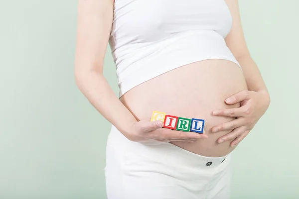 Jonge mooie zwangere vrouw met blokjes — Stockfoto