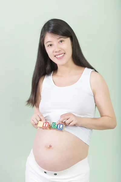 Giovane bella donna incinta con cubi — Foto Stock