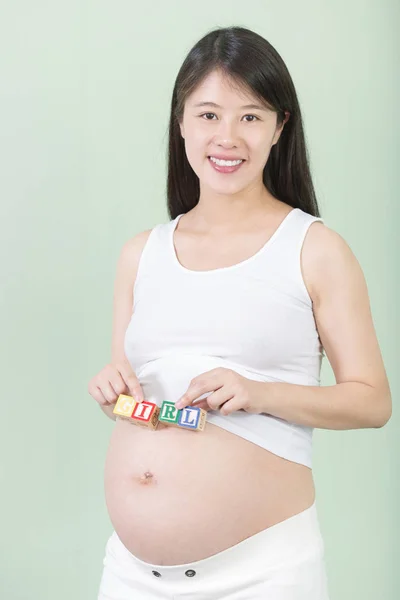 Jonge mooie zwangere vrouw met blokjes — Stockfoto