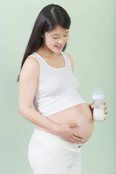 Pretty pregnant woman with milk bottle — Stock Photo, Image
