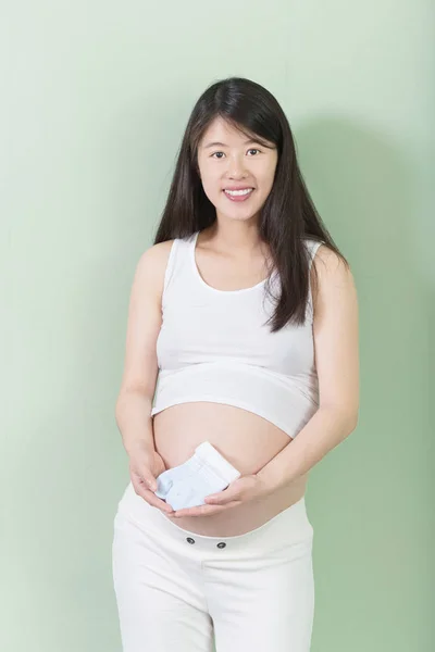 Junge hübsche schwangere Frau mit Socken — Stockfoto