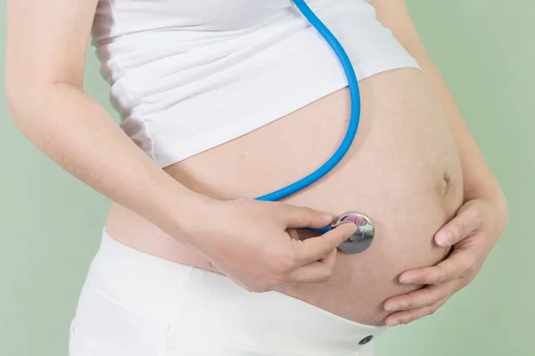 Hamile kadın ve stetoskop — Stok fotoğraf