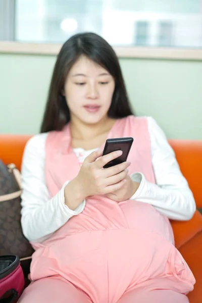 Vrij pregnat vrouw met mobiele telefoon — Stockfoto
