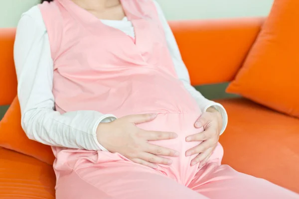 Jovem bonita pregnat mulher no sofá — Fotografia de Stock