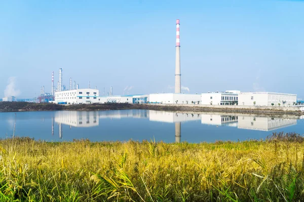 Construcciones en la moderna refinería de petróleo cerca del río —  Fotos de Stock