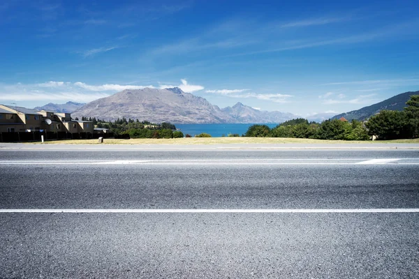 Empty asphalt road near water — Stock Photo, Image