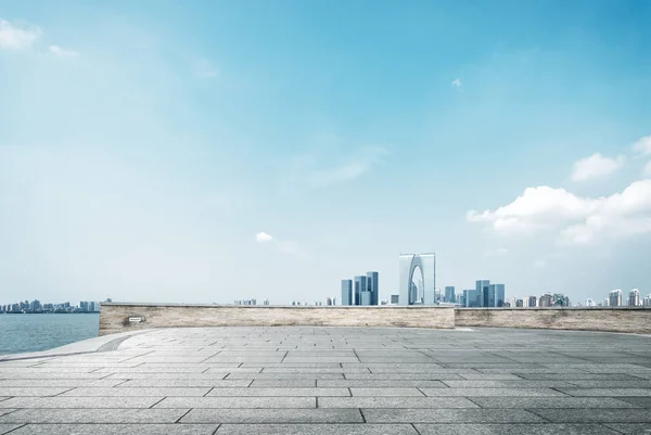 Пустой кирпичный пол и городской пейзаж современного города — стоковое фото