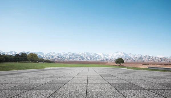 Empty brick floor with snow mountains — Stock Photo, Image