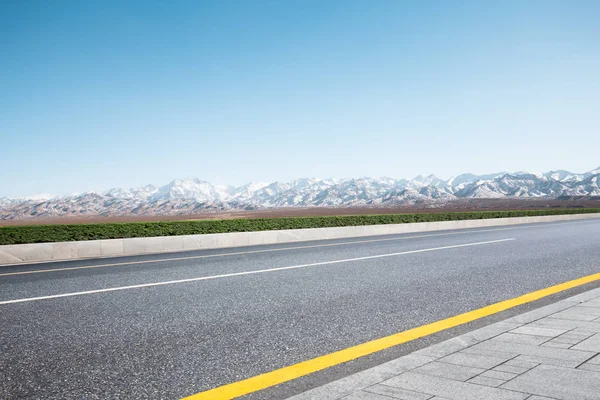 Empty road with snow mountains — Stock Photo, Image