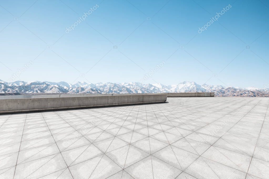 empty brick floor with snow mountains