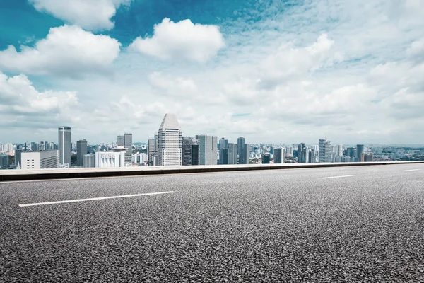 Empty road with cityscape of modern city — Stock Photo, Image