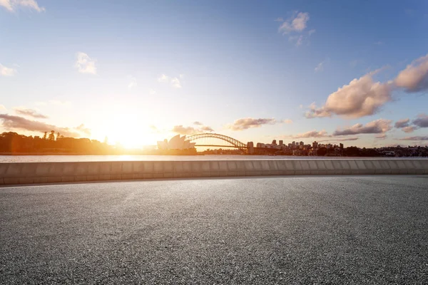 Landmark Sidney Köprüsü ve sydney opera binası gündoğumu boş yola gelen