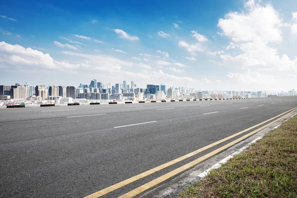 Strada asfaltata con paesaggio urbano della città moderna — Foto Stock