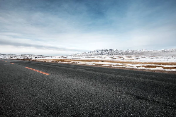 Camino de asfalto vacío con montañas de nieve — Foto de Stock