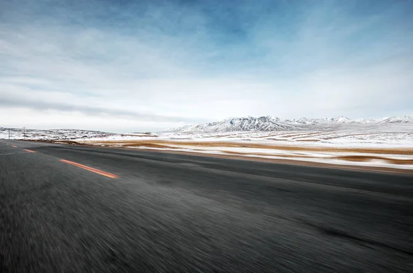 empty asphalt road near snow mountains