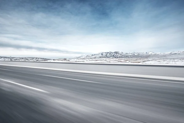 Camino de asfalto vacío cerca de montañas de nieve — Foto de Stock