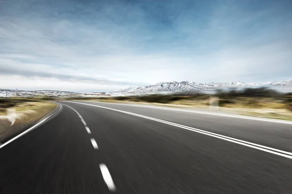 Порожня асфальтова дорога зі сніговими горами — стокове фото