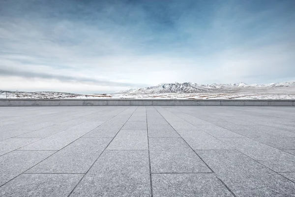 empty floor with white snow mountain