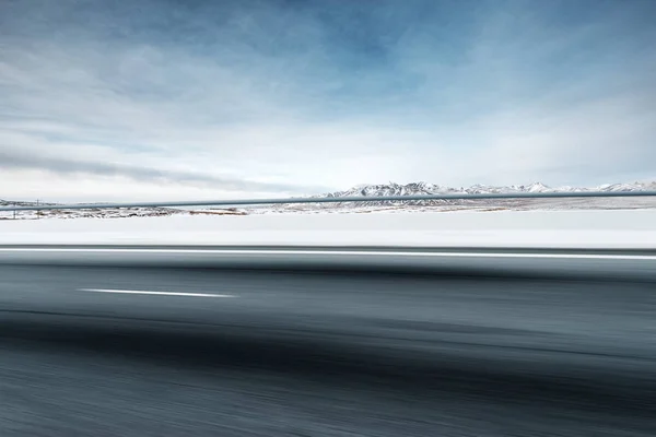 Пустая асфальтовая дорога со снежными горами — стоковое фото