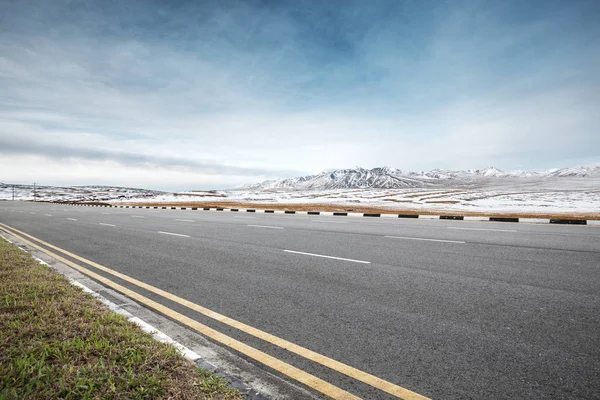 Prázdné asfaltové silnici s horách sníh — Stock fotografie