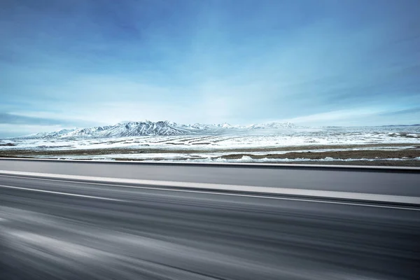 Leere Asphaltstraße mit Schneebergen — Stockfoto