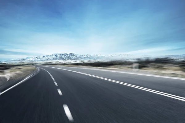 Leere Asphaltstraße mit Schneebergen — Stockfoto