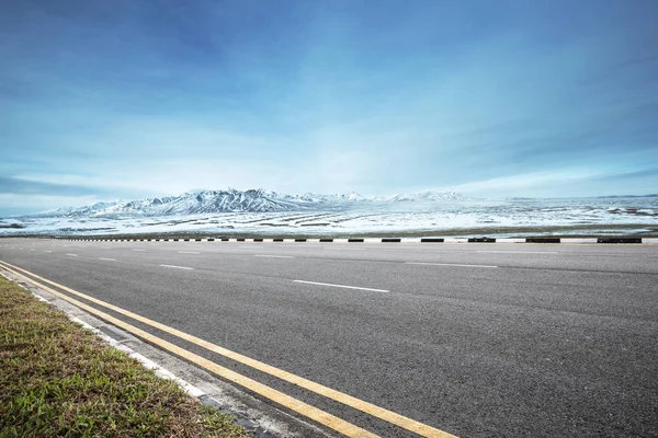 Prázdné asfaltové silnici s horách sníh — Stock fotografie