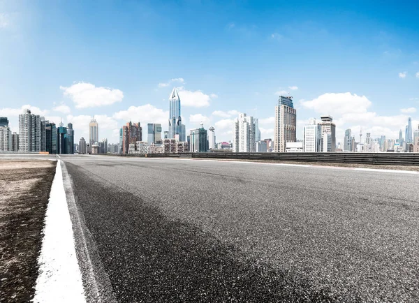 Strada asfaltata con paesaggio urbano della città moderna — Foto Stock
