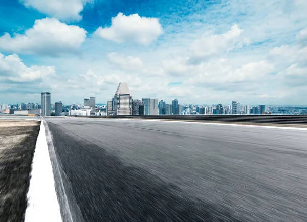 Strada asfaltata con paesaggio urbano della città moderna — Foto Stock