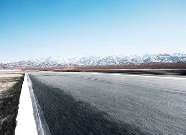 Route asphaltée vide avec montagnes de neige — Photo